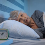 Worried senior woman in bed at night suffering from insomnia.